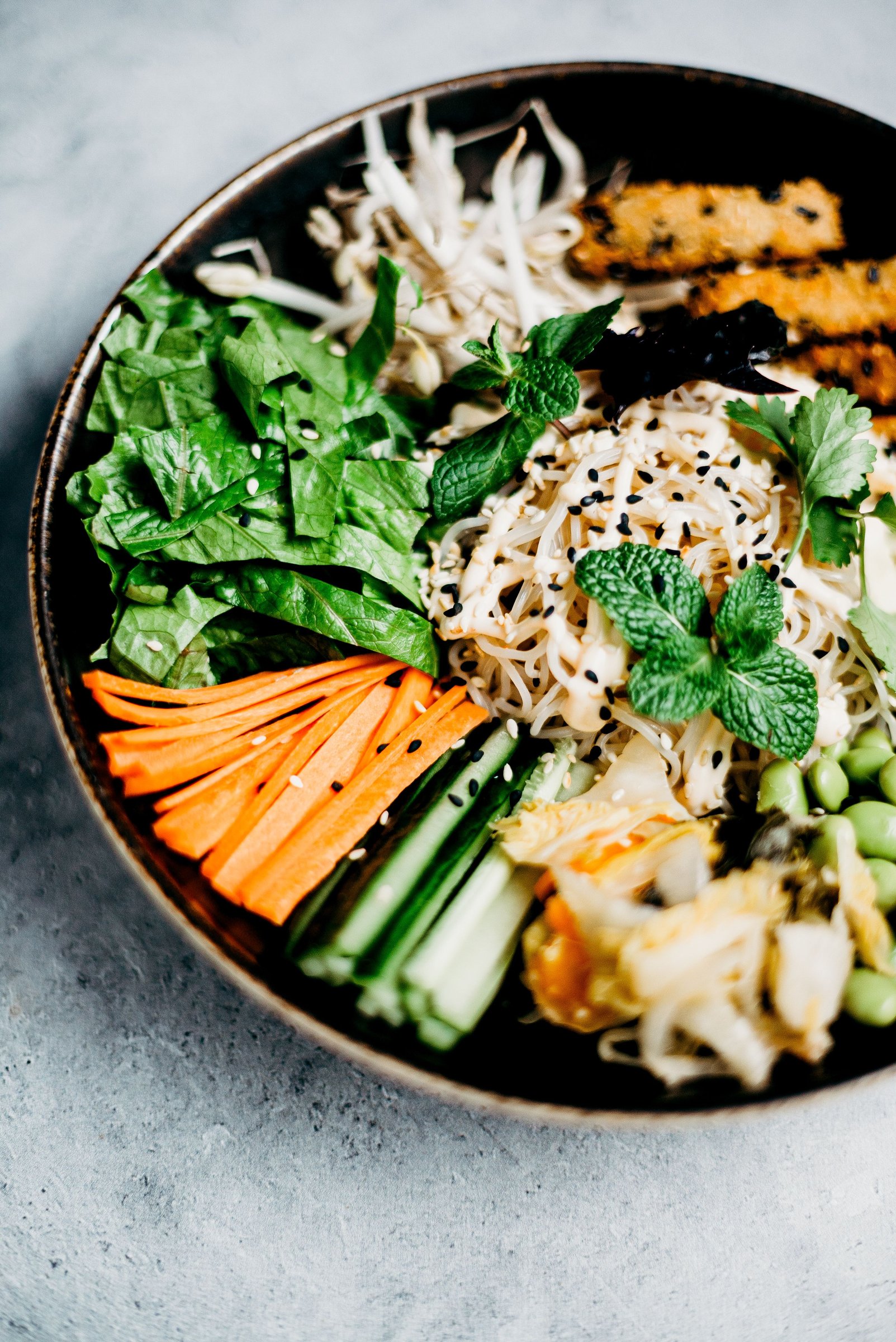 Asian-inspired noodle bowl with vegetables and fresh herbs