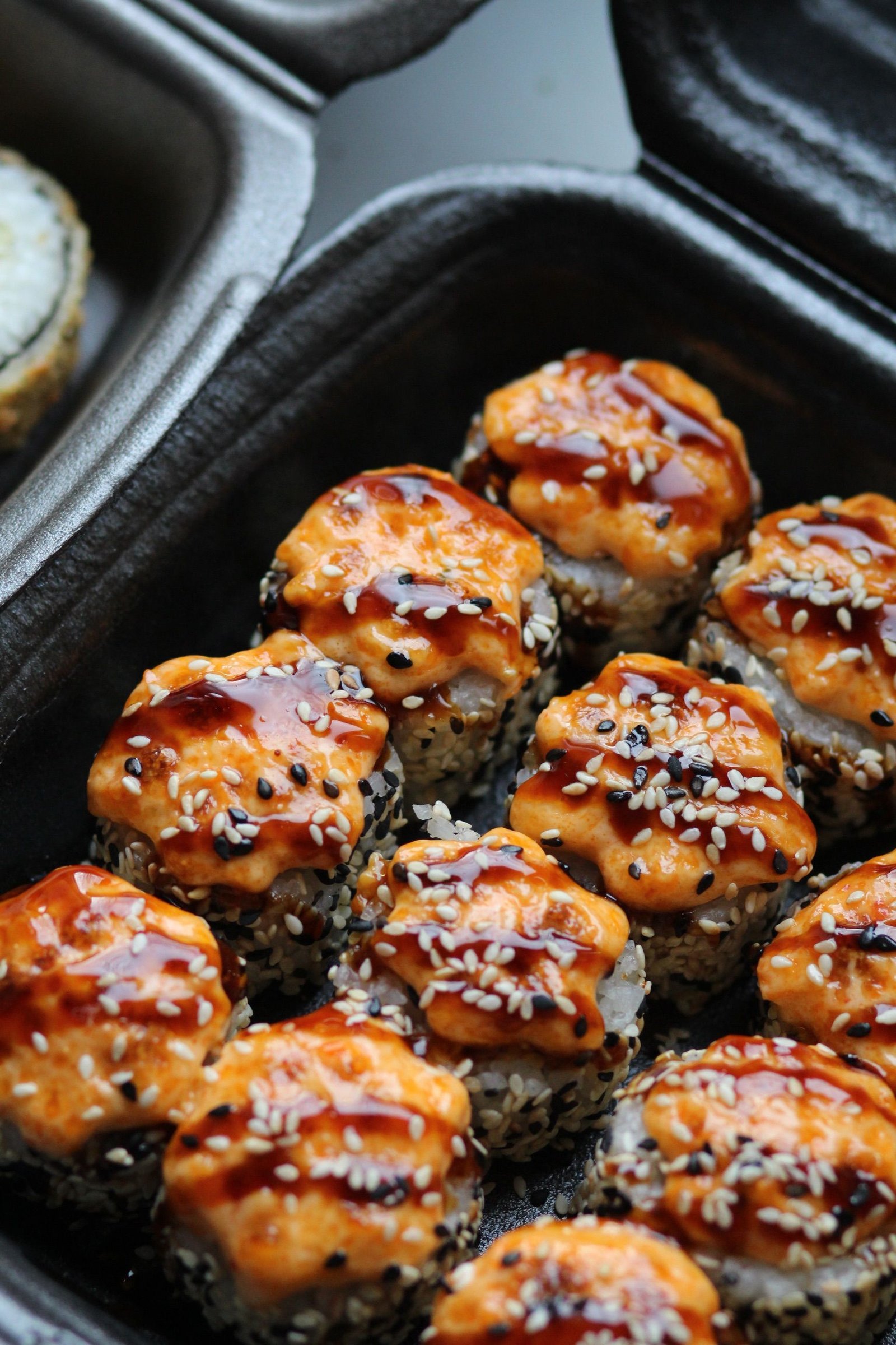 Sesame-crusted sushi bites topped with spicy sauce