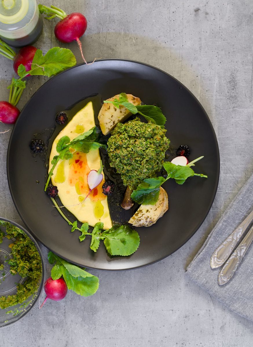 Finished basic polenta topped with herb pesto and radishes