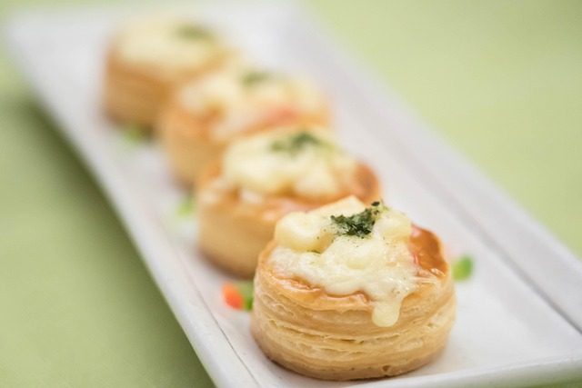 Finished golden puff-pastry vol-au-vent shells filled with creamy savory filling, plated as a French-style bouchée à la reine dish.