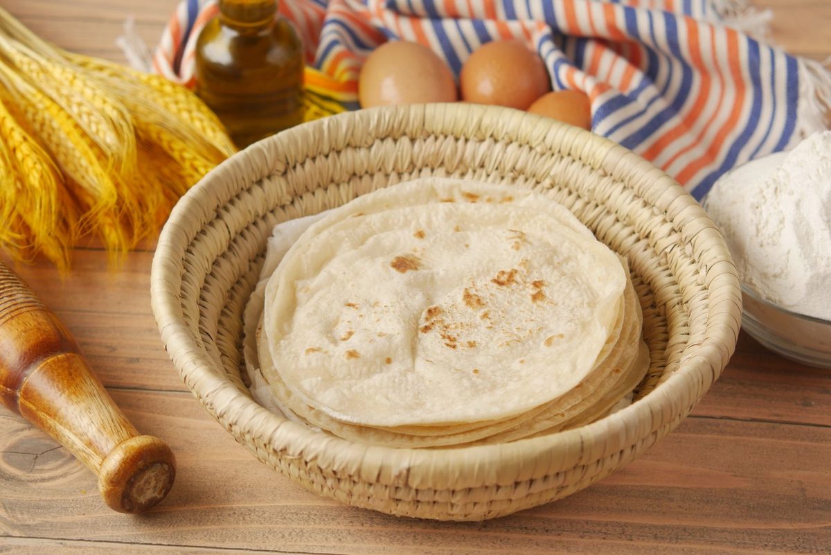 Finished chapati flatbreads stacked in a woven basket