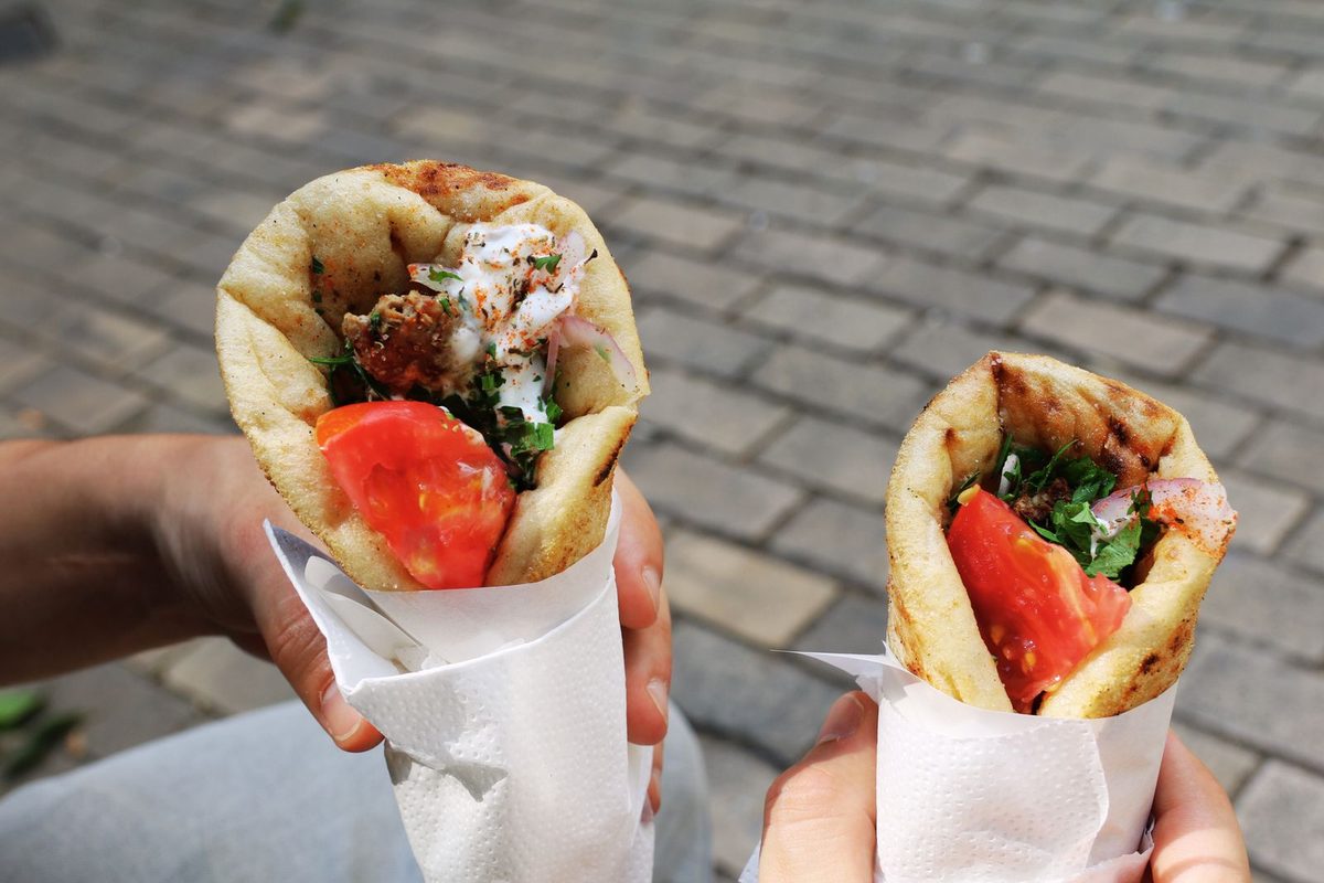 Finished Greek-style chicken gyros in pita with tomato and herbs