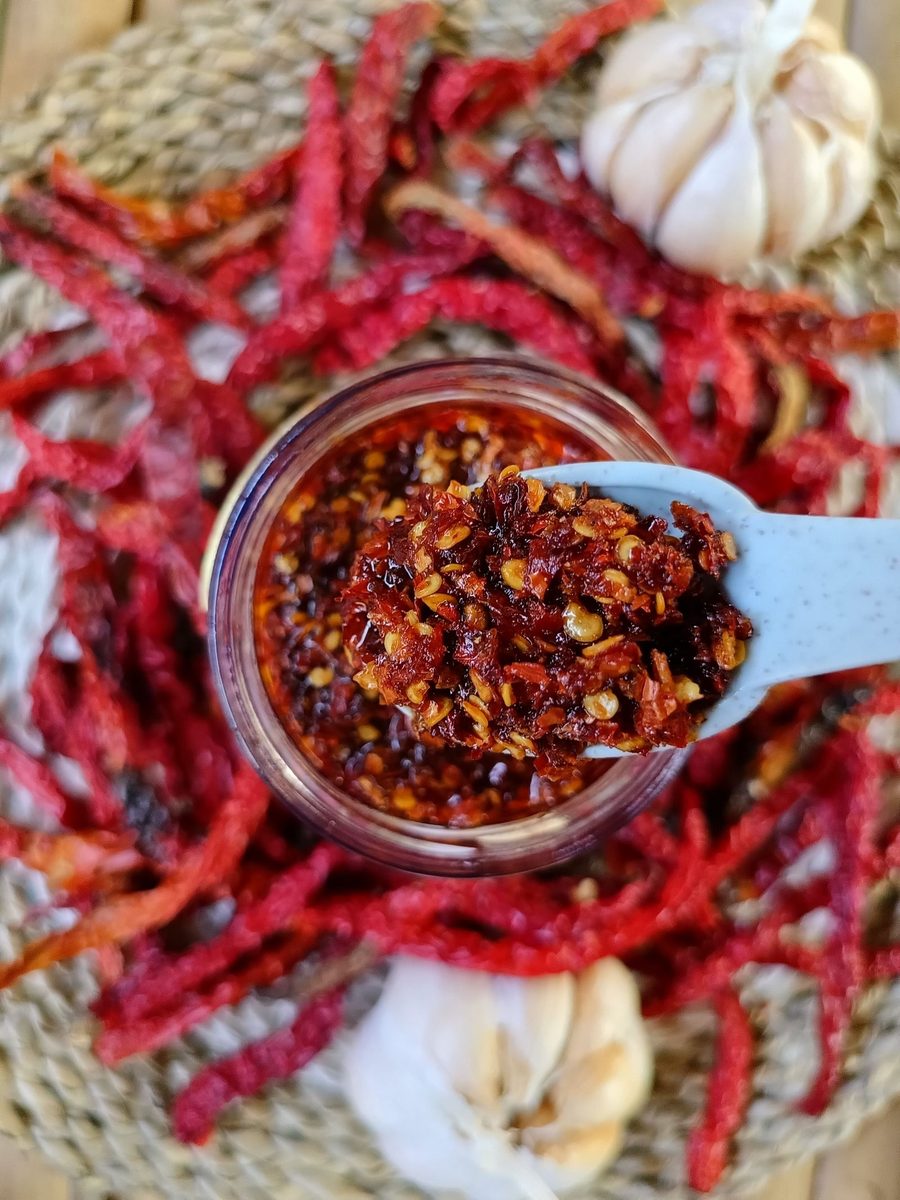 Finished chili oil with dried red chilies and garlic in a glass jar