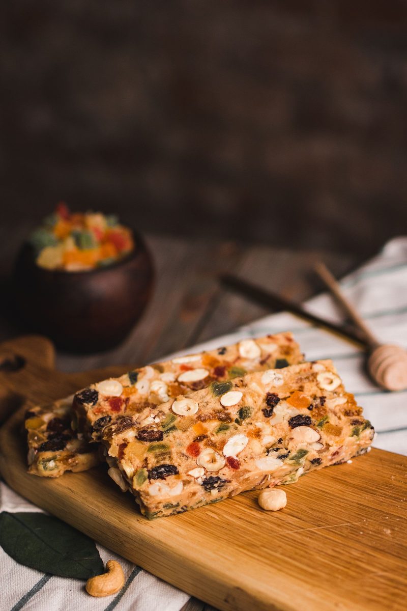 Finished Chinese Chews nut-and-date bars with nuts and dried fruit on a wooden board