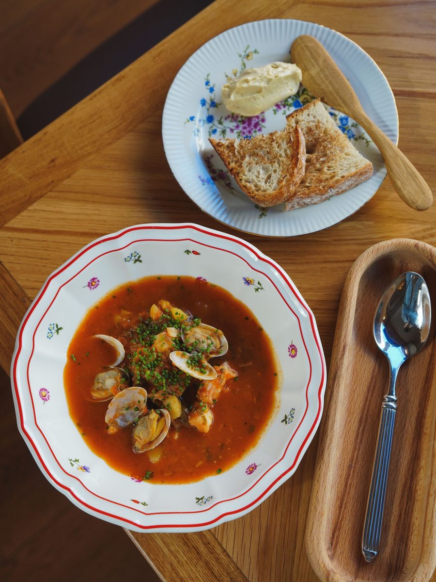 Finished Cioppino Italian seafood stew with clams and herbs, served with toasted bread