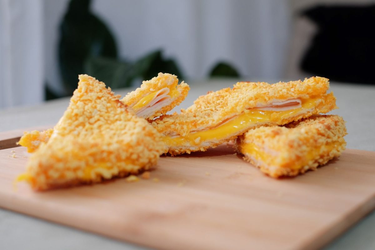 Finished Croque Monsieur with toasted bread, ham, and melted cheese, cut into triangles
