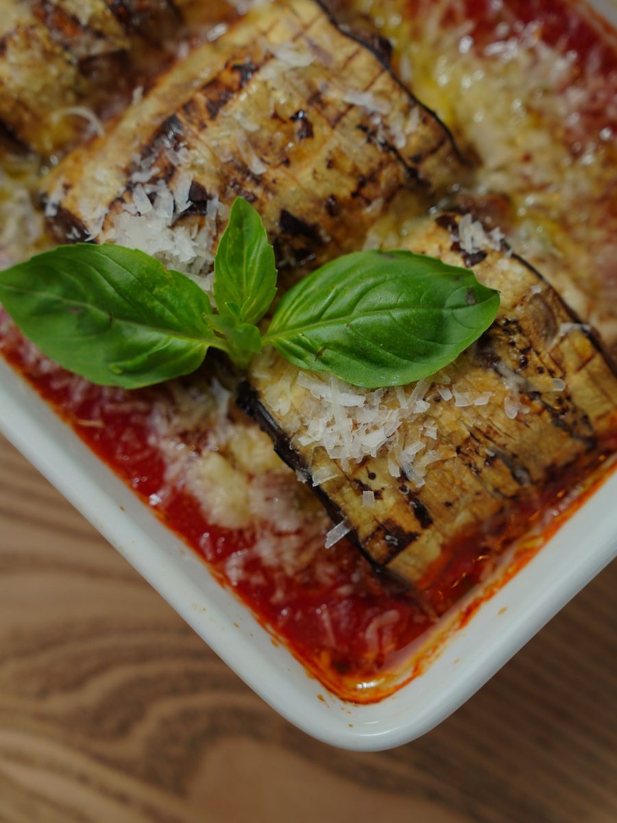 Finished eggplant Parmesan (melanzane alla parmigiana) baked with tomato sauce, melted cheese, and fresh basil
