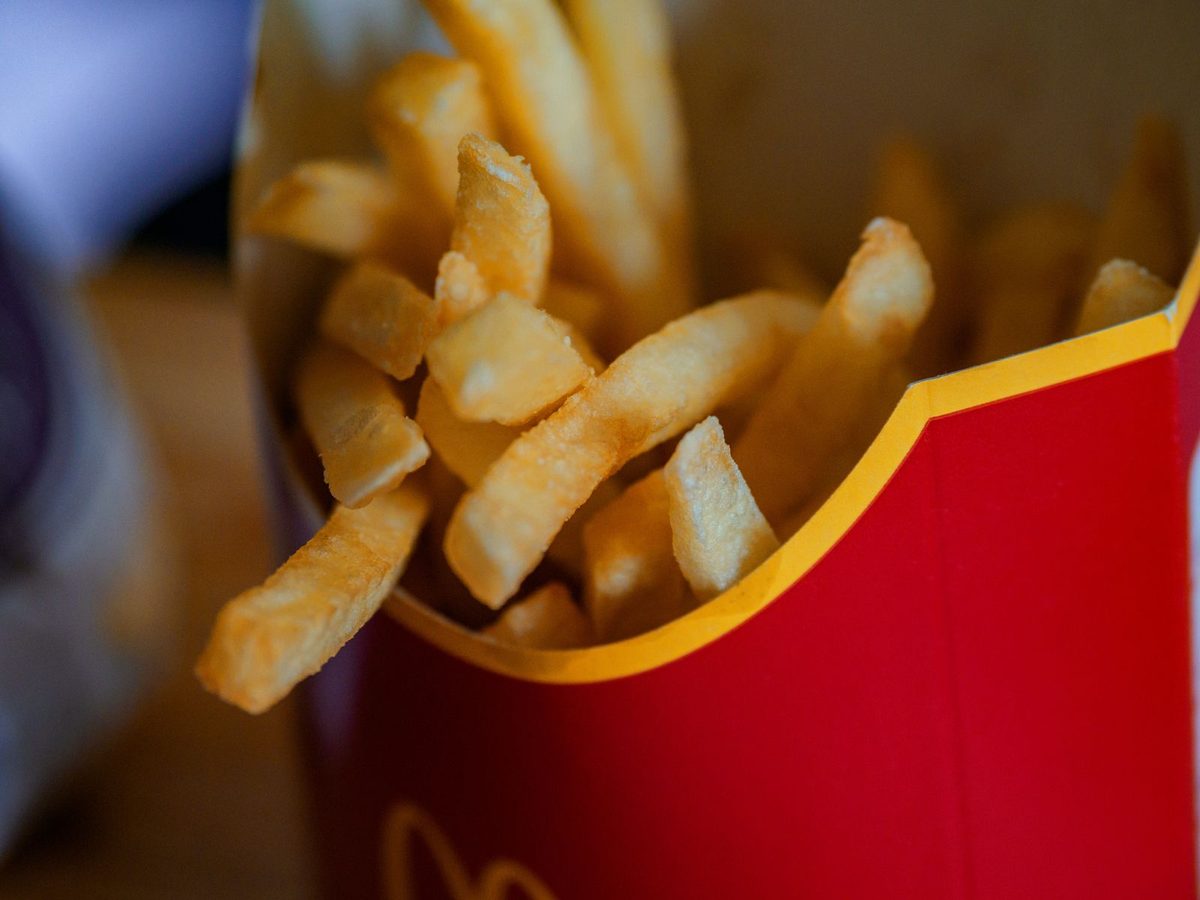Finished fast food French fries in a red takeout container