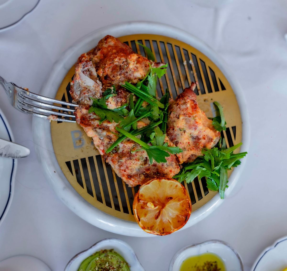 Greek-style grilled chicken with herbs and grilled lemon on a plate
