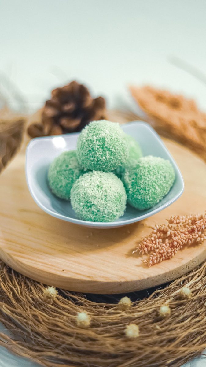 Finished Khanom Tian (Thai coconut rice dumplings), coconut-coated glutinous rice dumplings on a wooden board