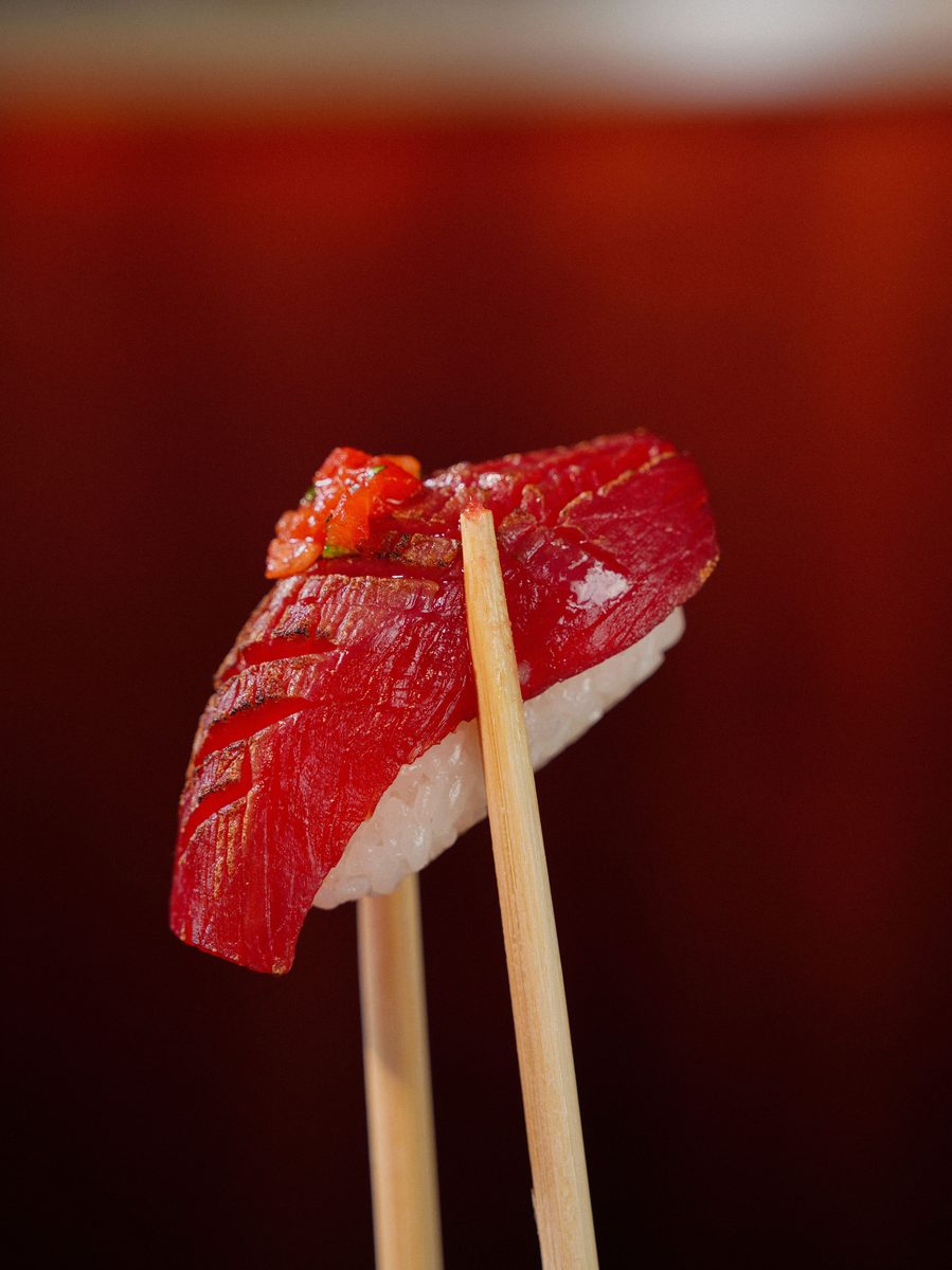 Finished tuna nigiri sushi with chopsticks