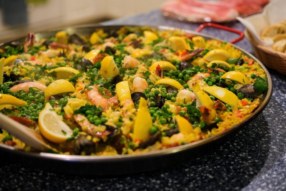 Finished Paella Roja with red-golden rice and seafood in a paella pan