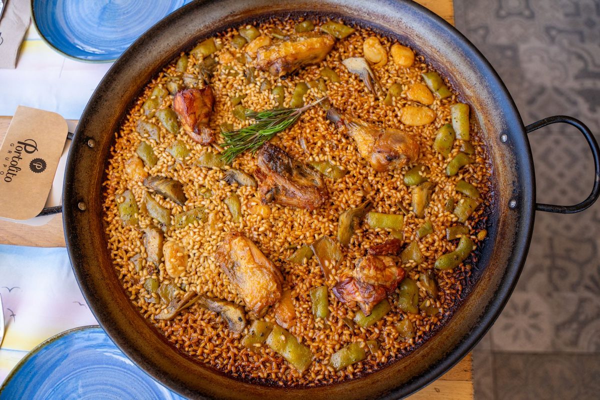 Finished Paella Valenciana with chicken and vegetables in a paella pan