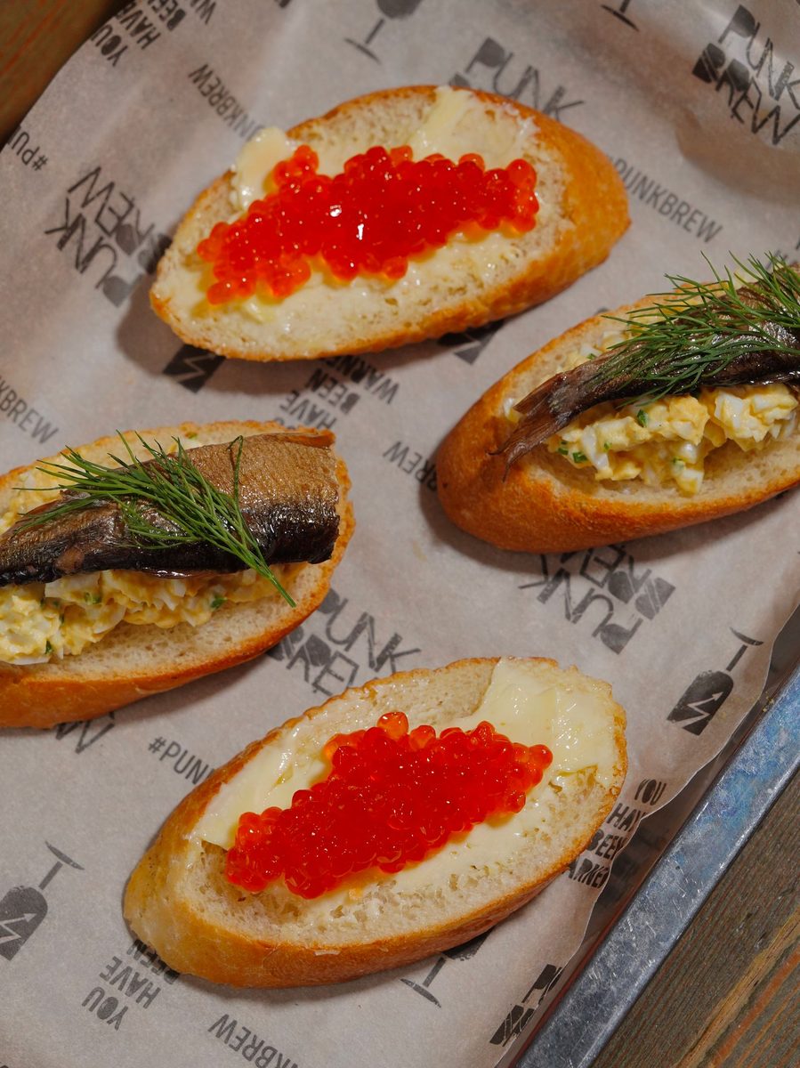 Finished seafood bruschetta appetizers topped with seafood and herbs on toasted bread
