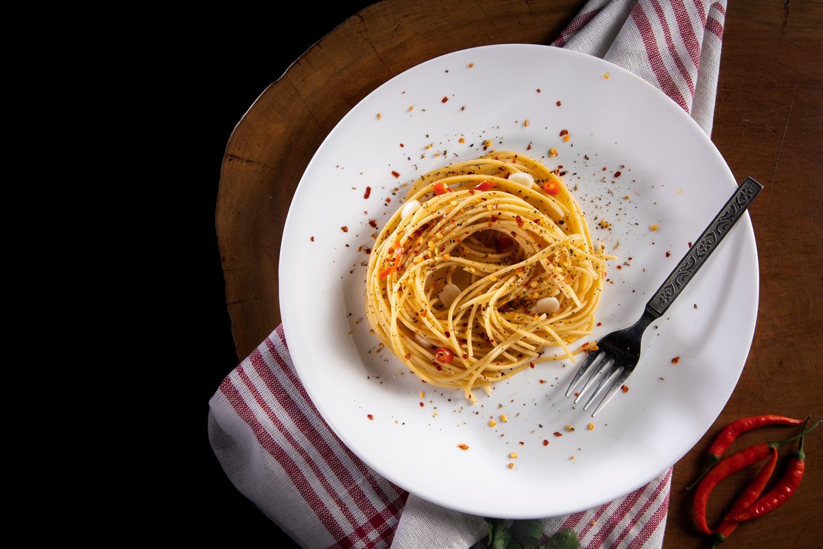 Finished plate of spaghetti aglio e olio with garlic, chili flakes, and parsley