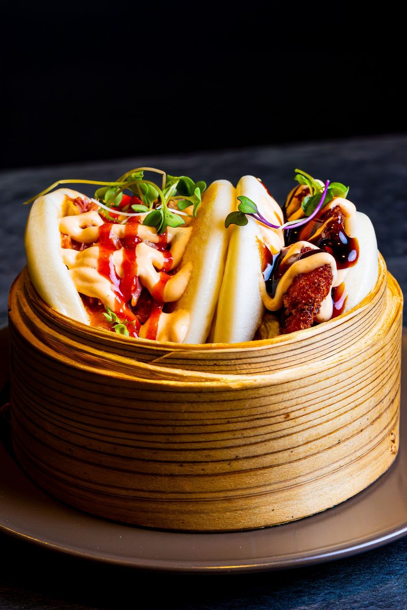 Finished steamed tuna bao buns in a bamboo steamer