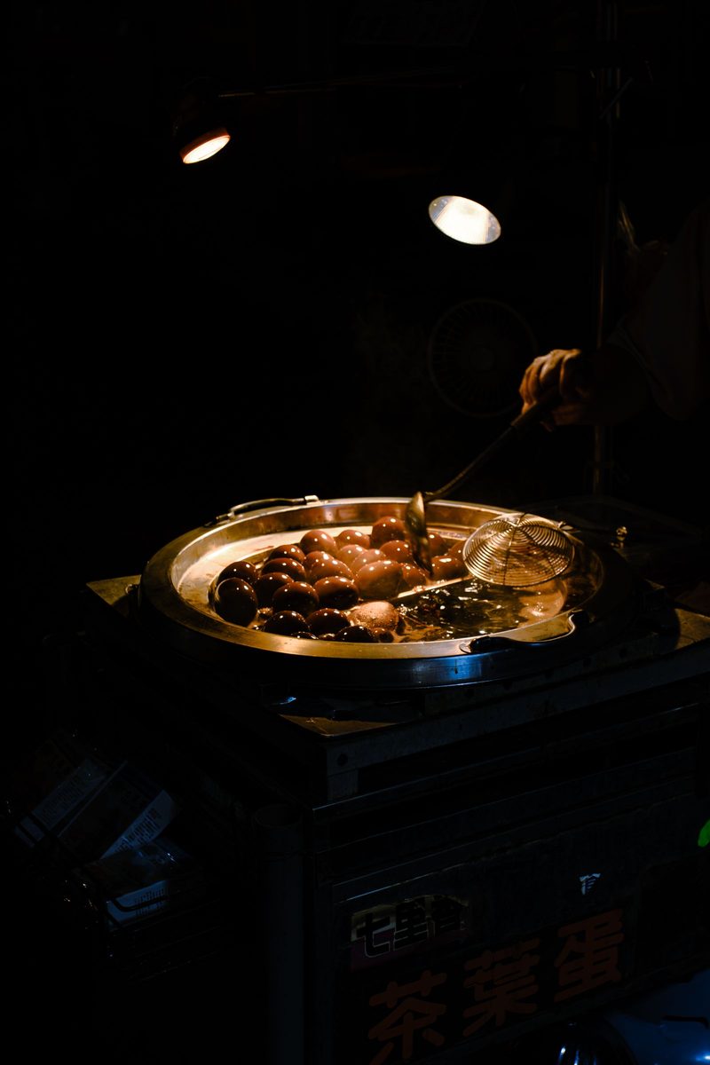Finished Chinese tea eggs simmering in a street-vendor pan