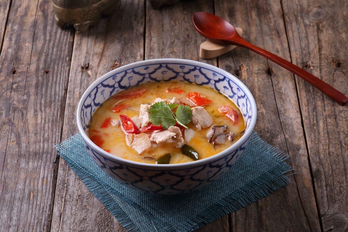 Bowl of Tom Kha Kai Thai coconut chicken soup with vegetables