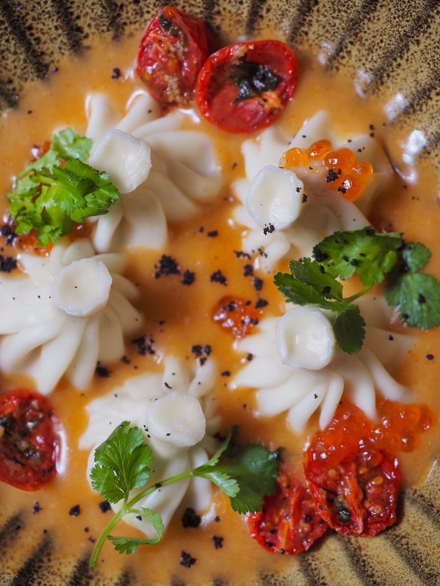 Finished wontons served in savory sauce with fresh herb garnish